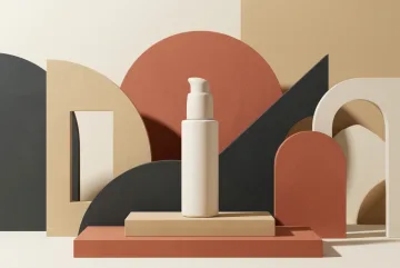 Unbranded skincare pump bottle on layered abstract geometric podiums with terracotta, cream, charcoal, and sand graphic shapes.
