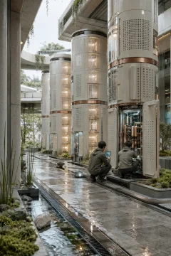 Portrait view of a sustainable atmospheric computing atrium with ceramic processor towers, rainwater cooling channels, moss beds, and two anonymous technicians.