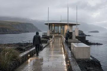 Cinematic rainy coastal causeway leading to a glass and ceramic signal pavilion above a dark tidal basin, with two anonymous maintenance workers and misty cliffs in the distance.